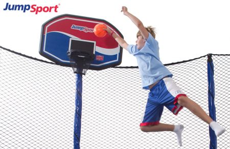 Young boy jumping and dunking his JumpSport ProFlex trampoline basketball hoop