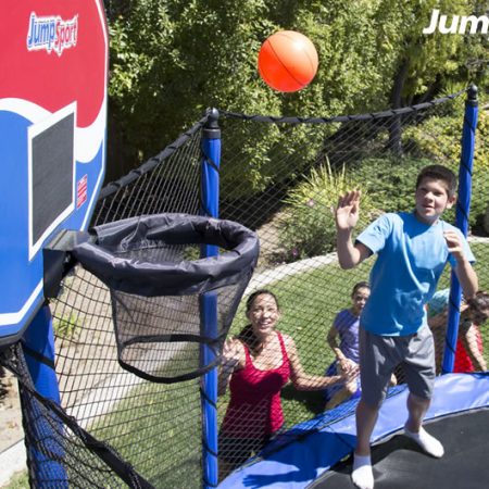 A group of kids watch breathlessly to see if their friends shot makes it into the trampoline hoop