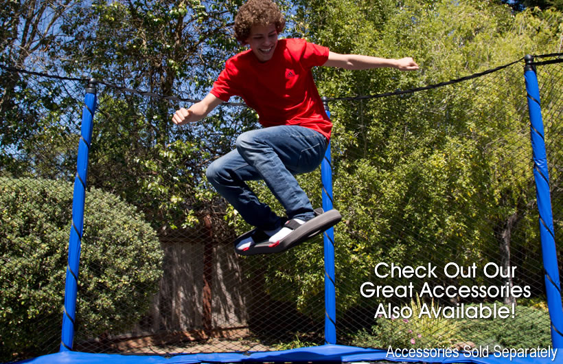 A teenage boy uses his skate deck to perform aerial tricks on his trampoline