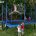 A little girl does gymnastics tricks on her rectangular trampoline