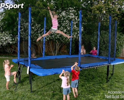 A little girl does gymnastics tricks on her rectangular trampoline