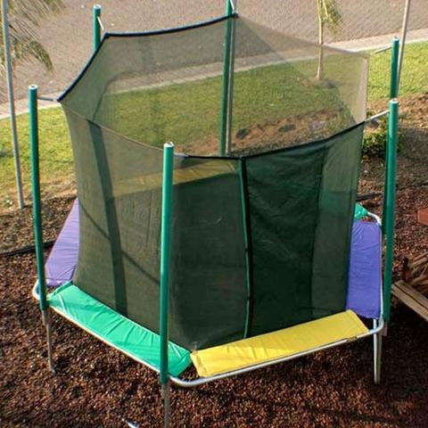 Hexagon shaped, colorful trampoline on bark at a schoolyard park