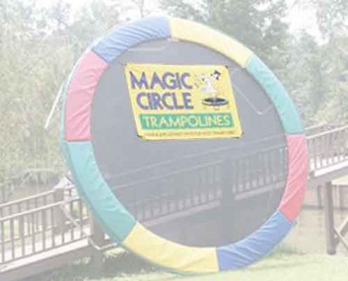 A Magic Circle trampoline leaned up against a fence