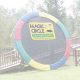 A Magic Circle trampoline leaned up against a fence