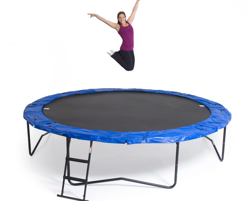 A woman bouncing and posing on a JumpSport trampoline without safety enclosure