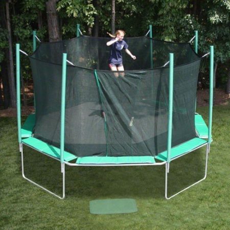 An octagon shaped trampoline with a young girl with ponytails jumping.