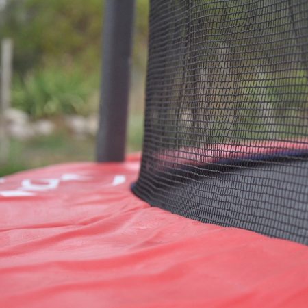 Close up picture of a red trampoline pad and safety net