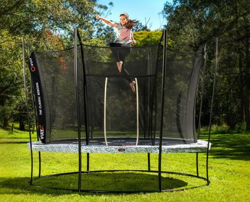 A teenage girl jump punches on a 14 foot Vuly 2 trampoline