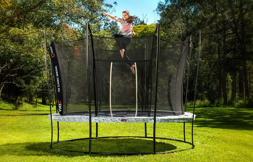 A teenage girl jump punches on a 14 foot Vuly 2 trampoline