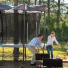 A family of four camp in the woods next to their Vuly 2 Trampoline and tent