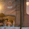 A father and mother use a flashlight to read to their kids before bedtime in a Vuly 2 Tent